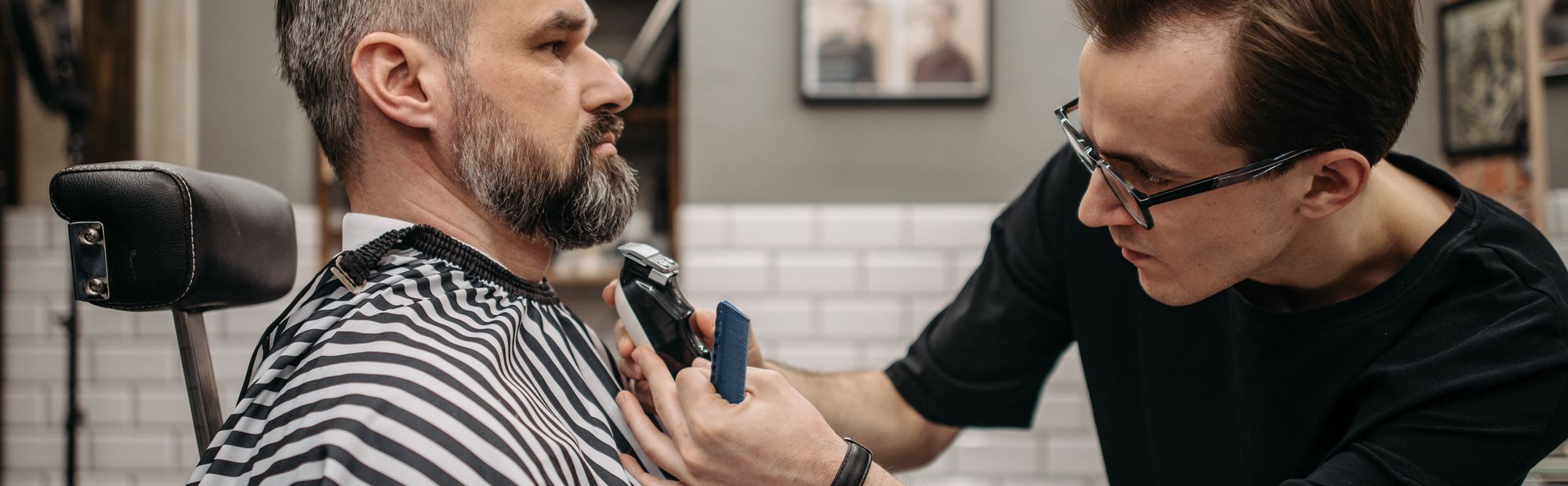 Barber wykańcza zarost klienta w barbershopie